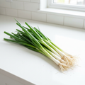 Fresh bunching onions on a crisp white kitchen bench