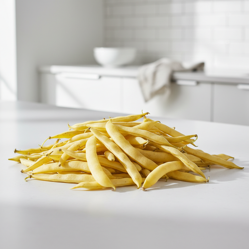 Fresh Berrygold dwarf butter beans, bright golden-yellow pods piled on a white kitchen bench