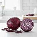 Whole and halved red cabbage showing stunning swirling purple interior on a bright airy kitchen bench