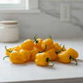 Fresh yellow habanero chillies piled abundantly on a bright kitchen bench