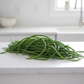 Fresh Green Noodle beans, extraordinarily long slender green pods piled naturally on a white kitchen bench