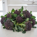Fresh purple sprouting broccoli on a bright kitchen bench