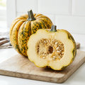 Original Kumi Kumi squash image with golden-yellow and green skin, deep rounded ribs and a cut seed-filled centre